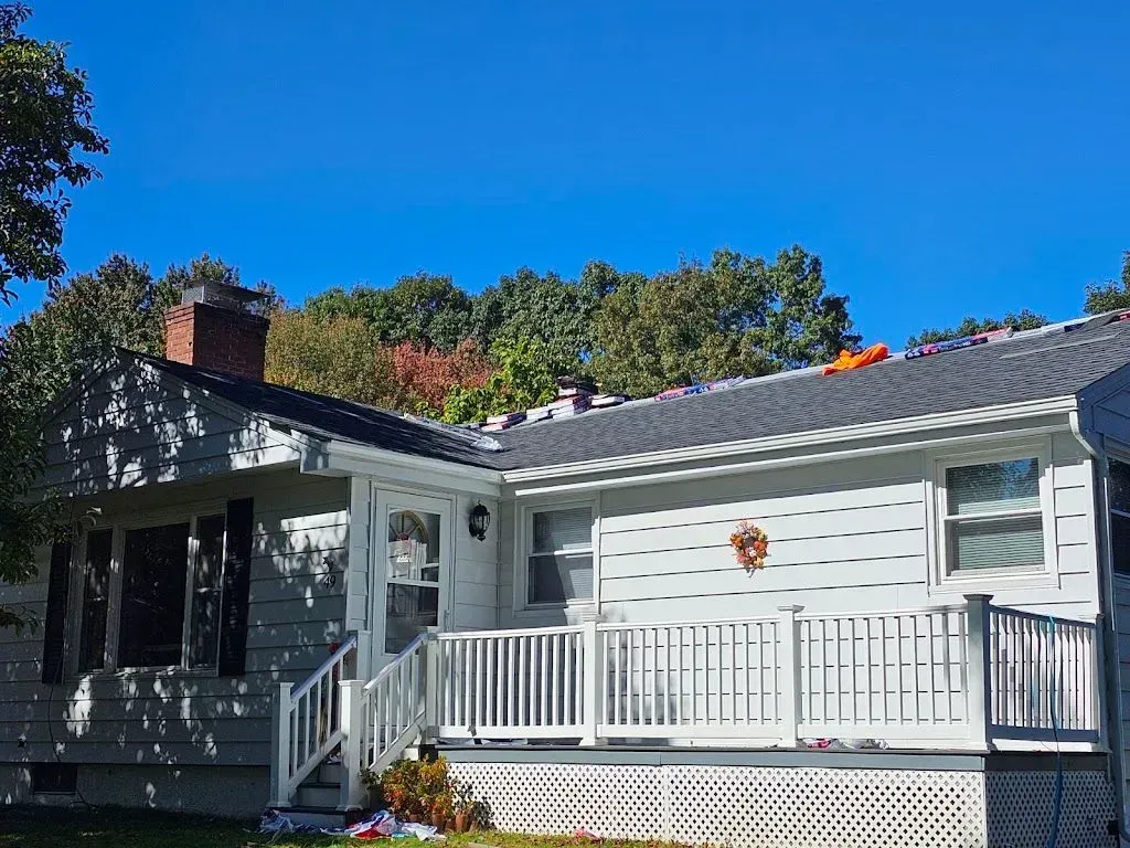 A white house with a porch and a chimney