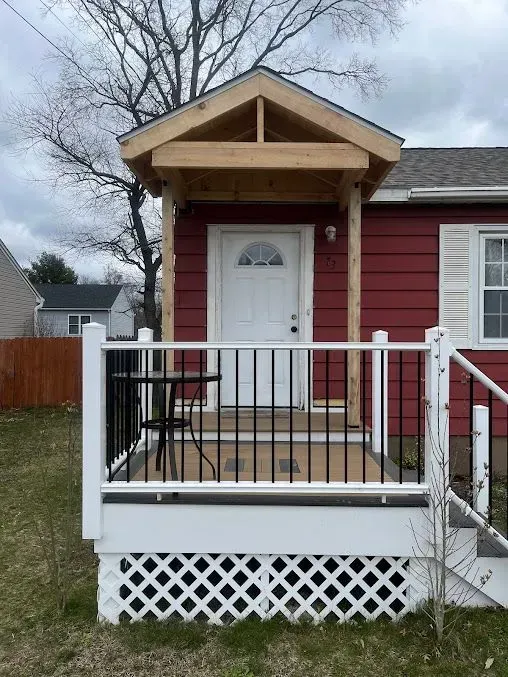 A red house with a white porch and stairs