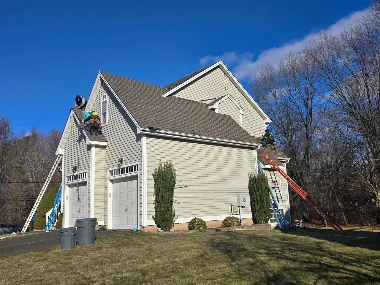 A couple of men are working on the roof of a house.
