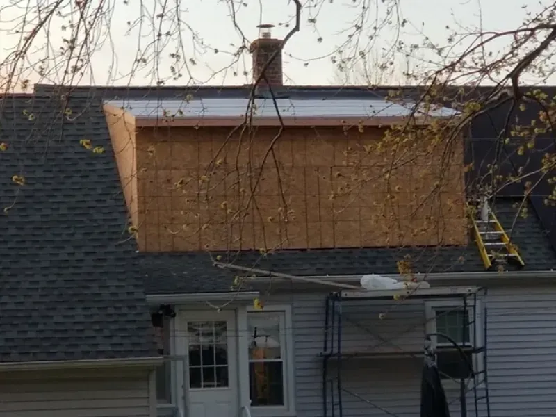 A house with a chimney on the roof is being remodeled.