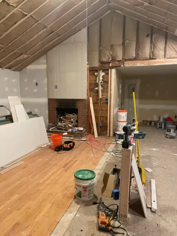 A room that is being remodeled with wooden floors and a fireplace.