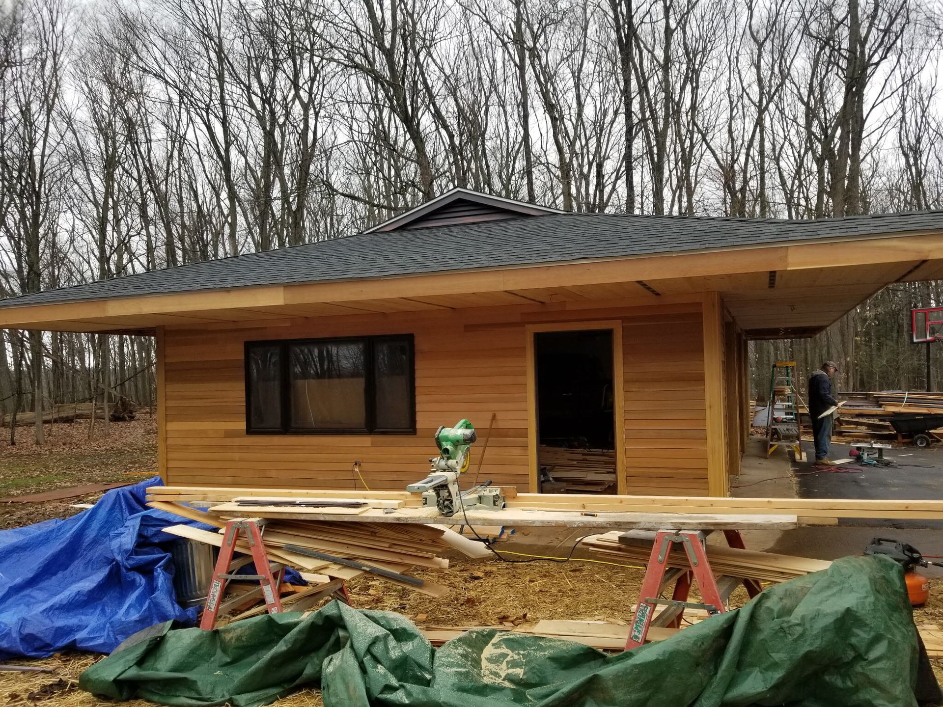 A small wooden house is being built in the middle of a forest.
