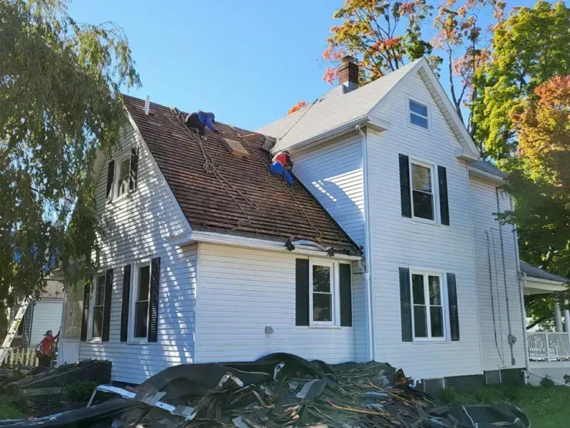 A white house with a brown roof and black shutters