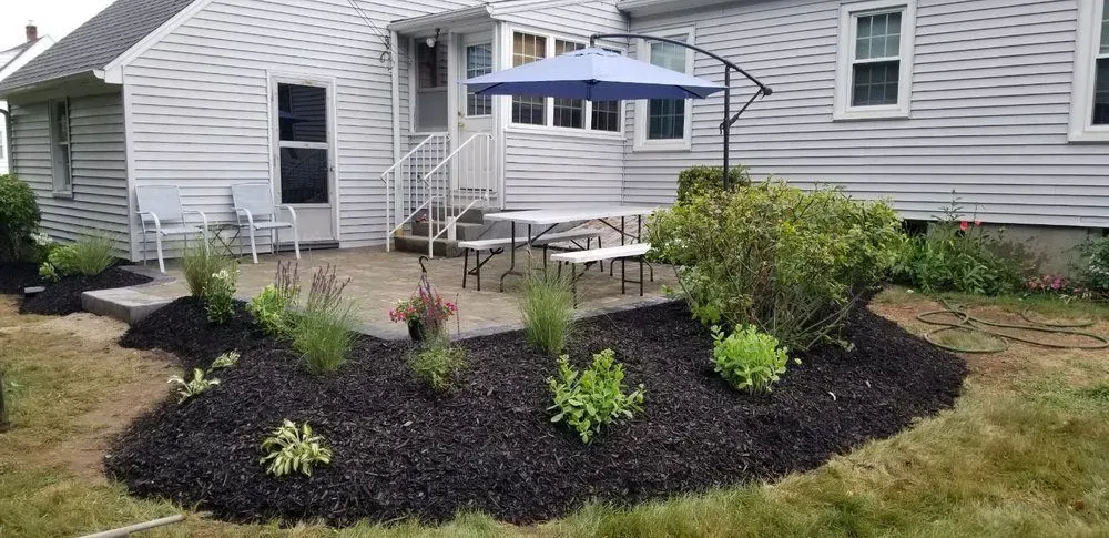 There is a blue umbrella in the backyard of a house.