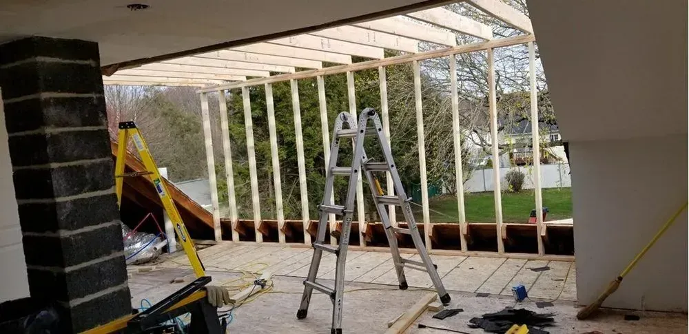 A ladder is sitting in the middle of a room under construction.