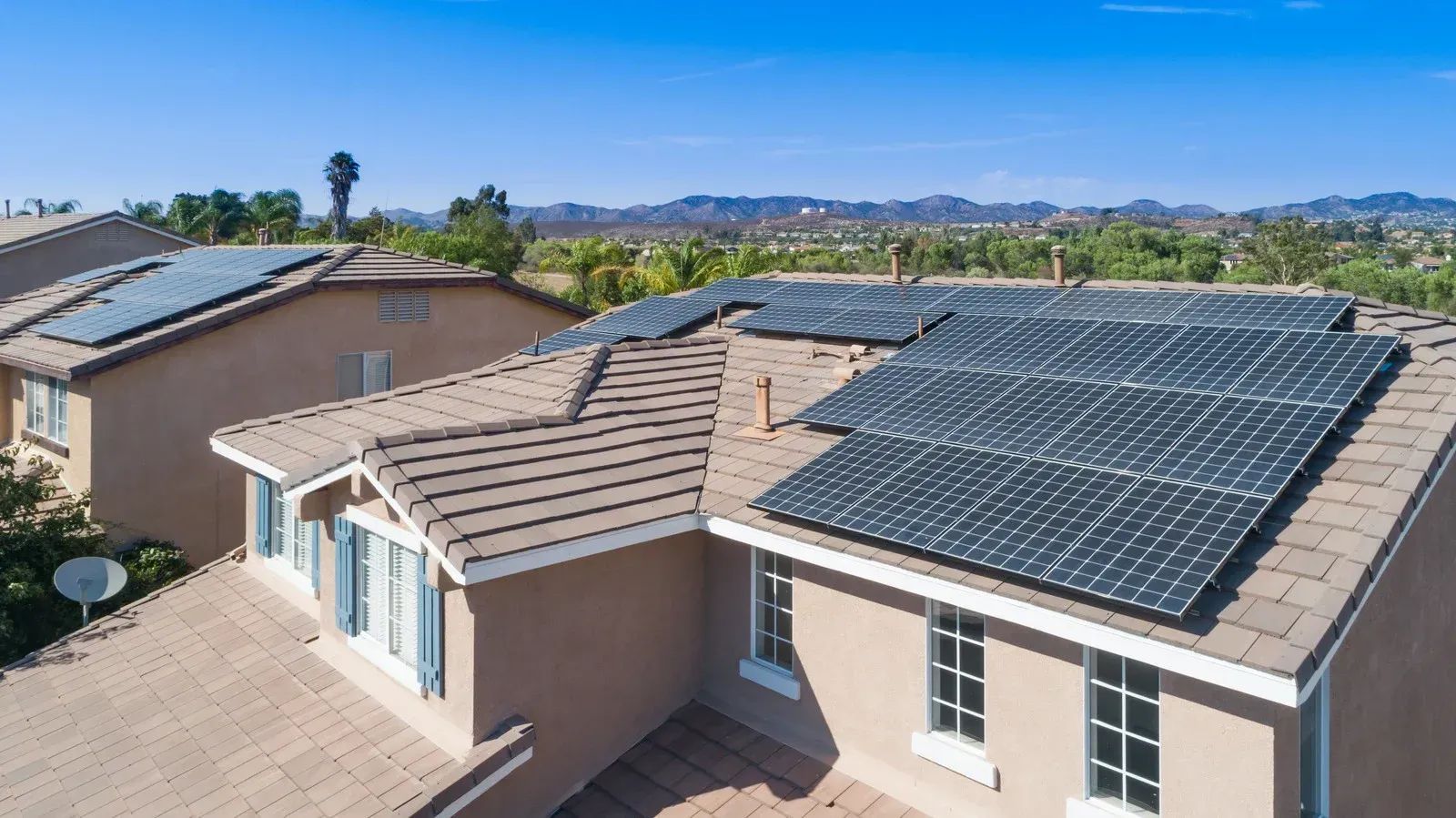 An aerial view of a house with solar panels on the roof.