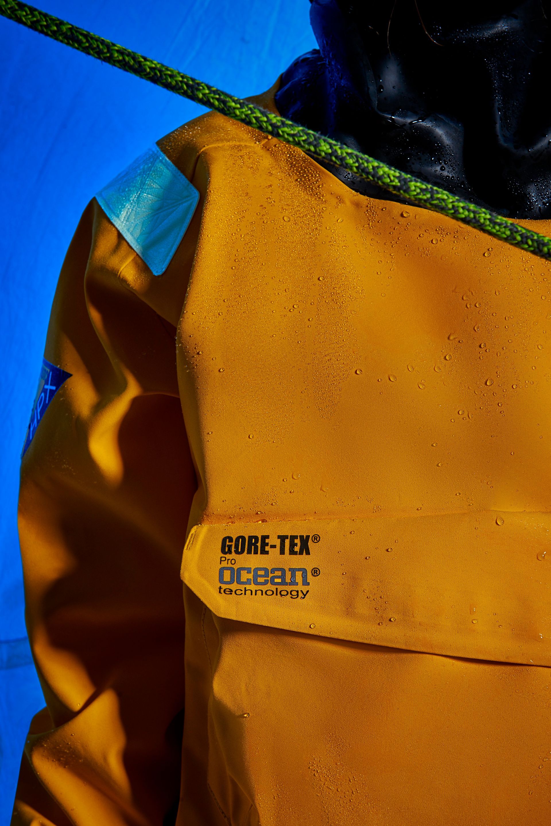 a close up of a person wearing a yellow jacket and holding a rope .