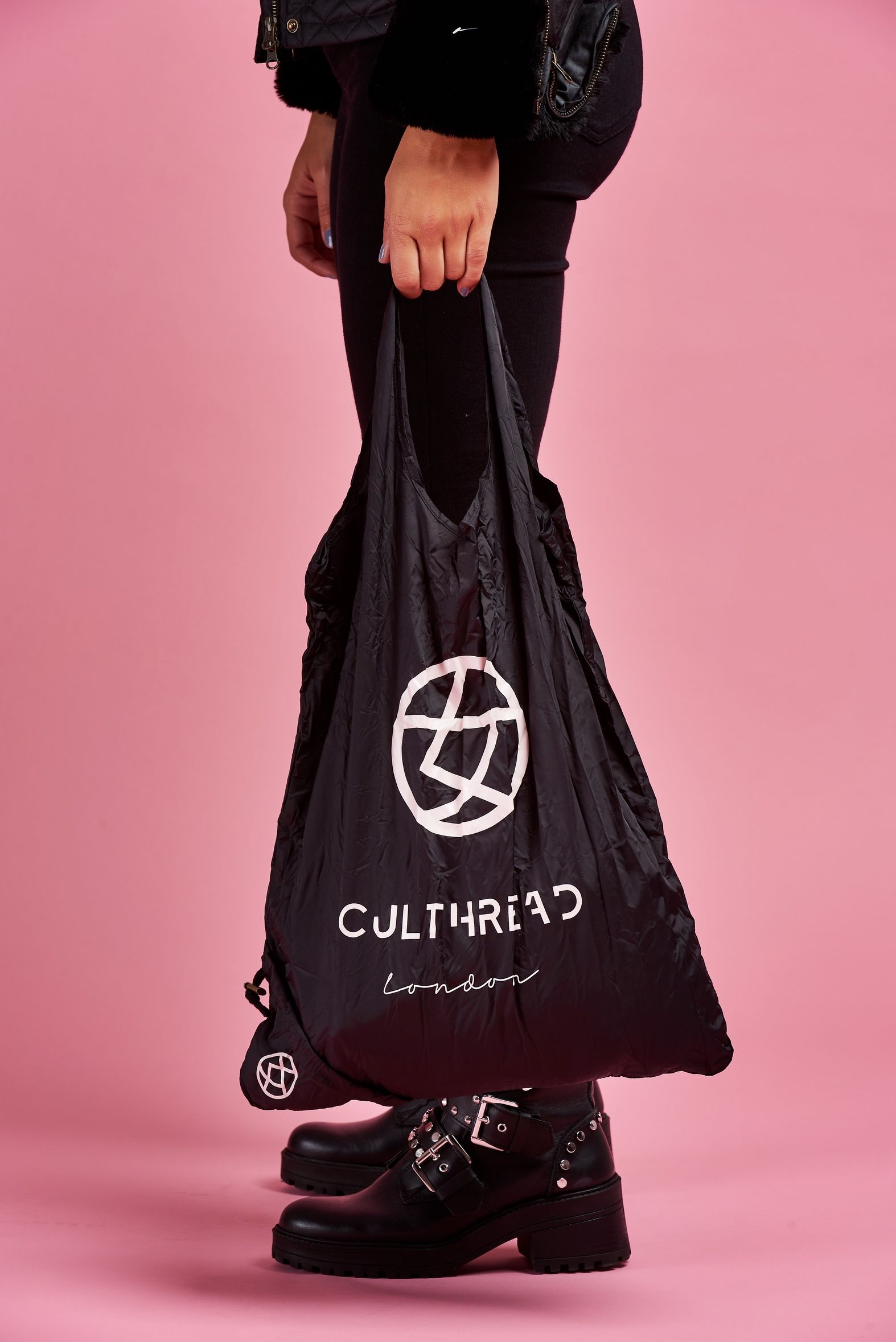 a person is holding a black bag with a white logo on it .