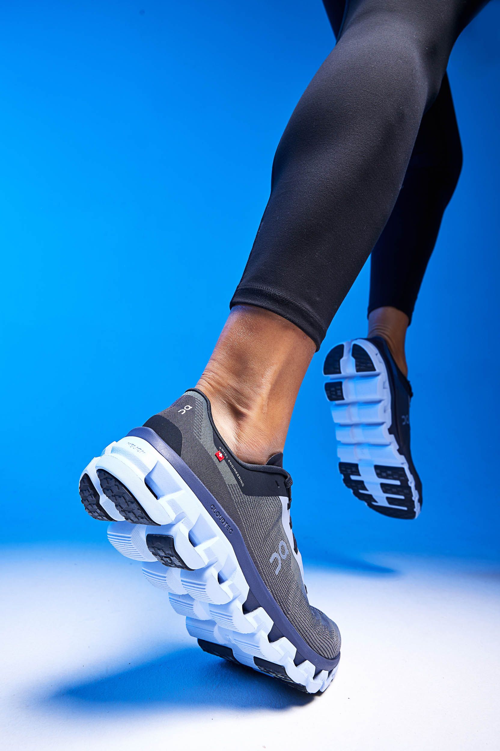 a person wearing a pair of running shoes is jumping in the air .