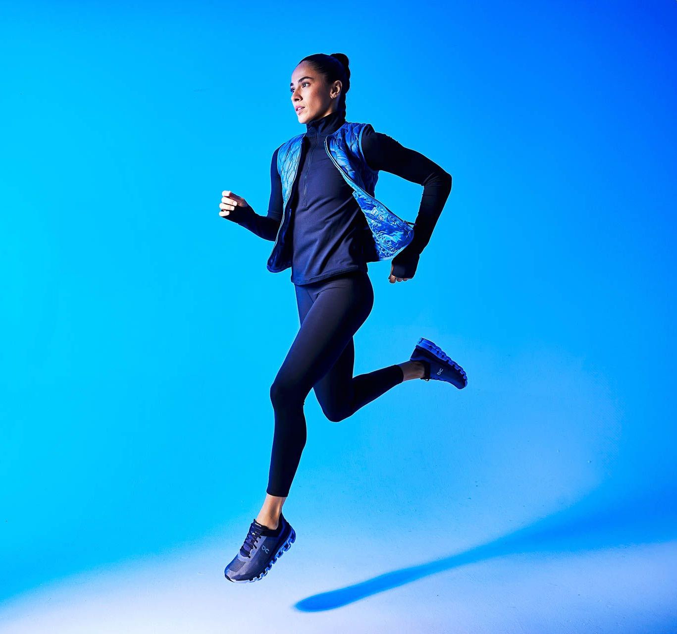 a woman is running in the air on a blue background .