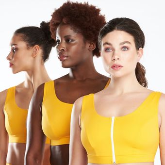 three women wearing yellow sports bras are standing next to each other