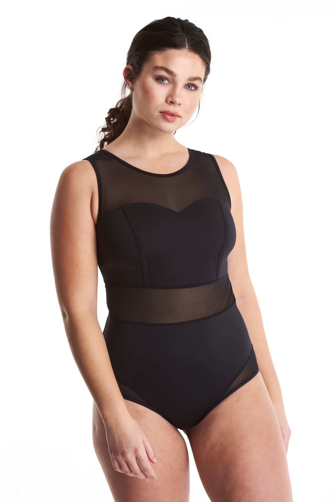 a woman in a black bodysuit is standing on a white background .