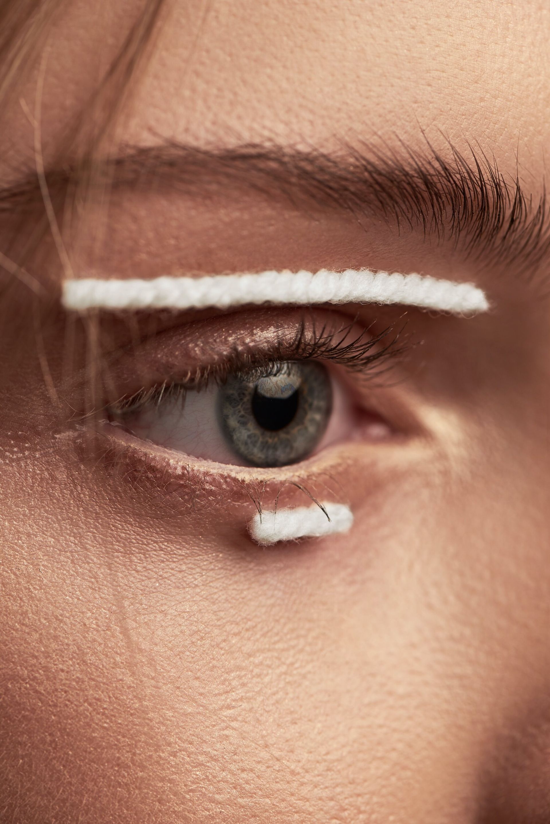 A close up of a woman 's eye with white eyeliner.