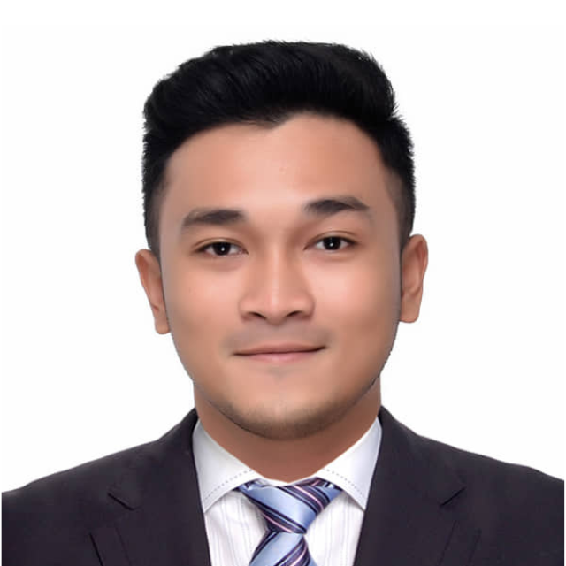 Woman wearing glasses and blazer, smiling, headshot against white background.