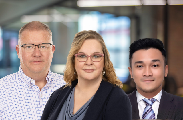 Three people in business attire smiling at the camera.
