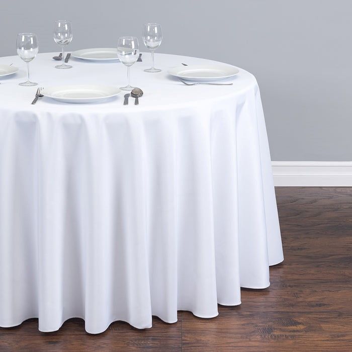 A round table with plates and wine glasses on it