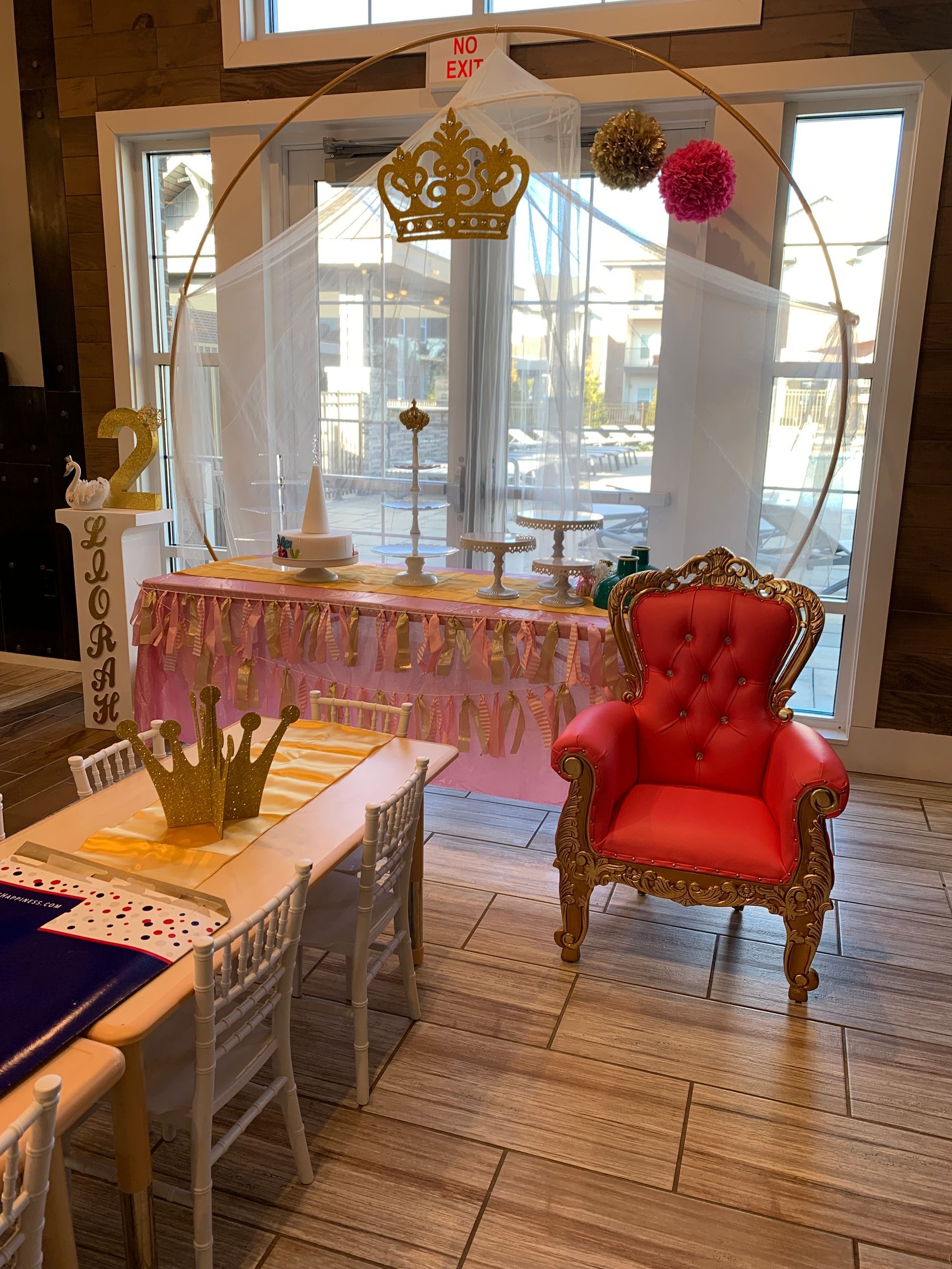 A room with a table and chairs and a chair with a crown on it.