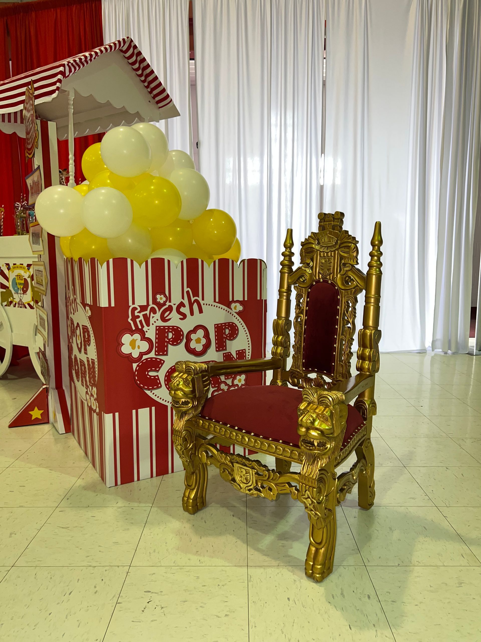 A gold chair is sitting in front of a popcorn cart.