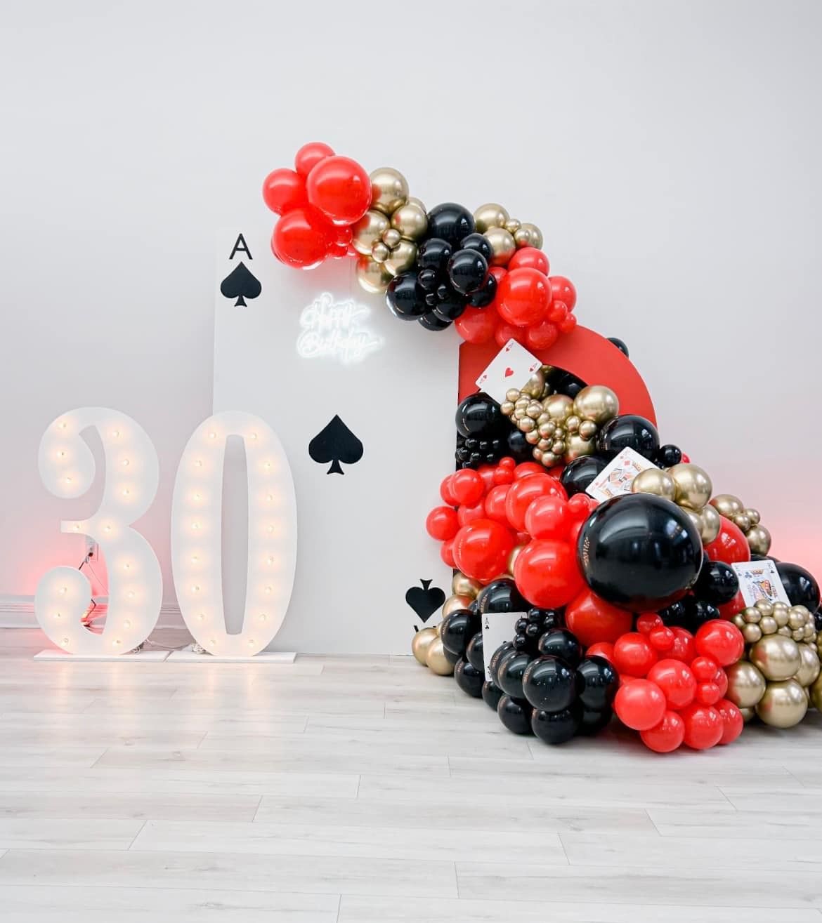 A throne with a crown on it is surrounded by flowers and candles.