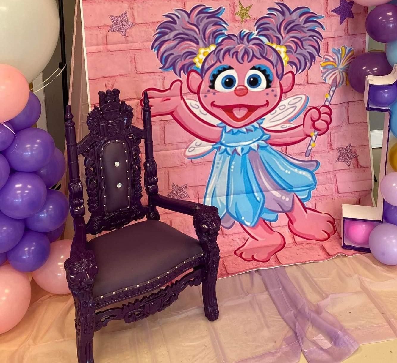 A chair is sitting in front of a wall decorated with balloons.