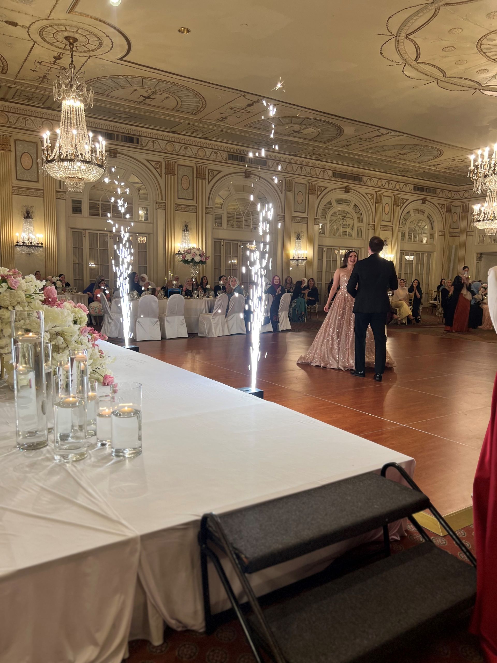 A table with a ring light and props on it in front of a wall of barrels.