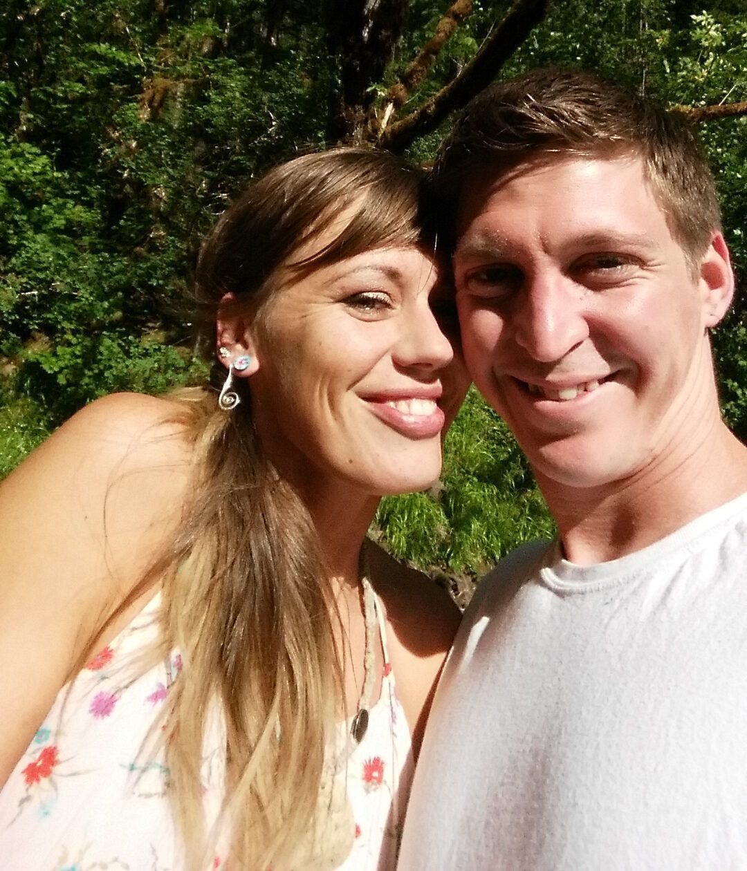 A man and a woman are posing for a picture and smiling