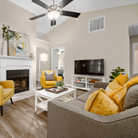 A living room with a couch , chair , coffee table and television.