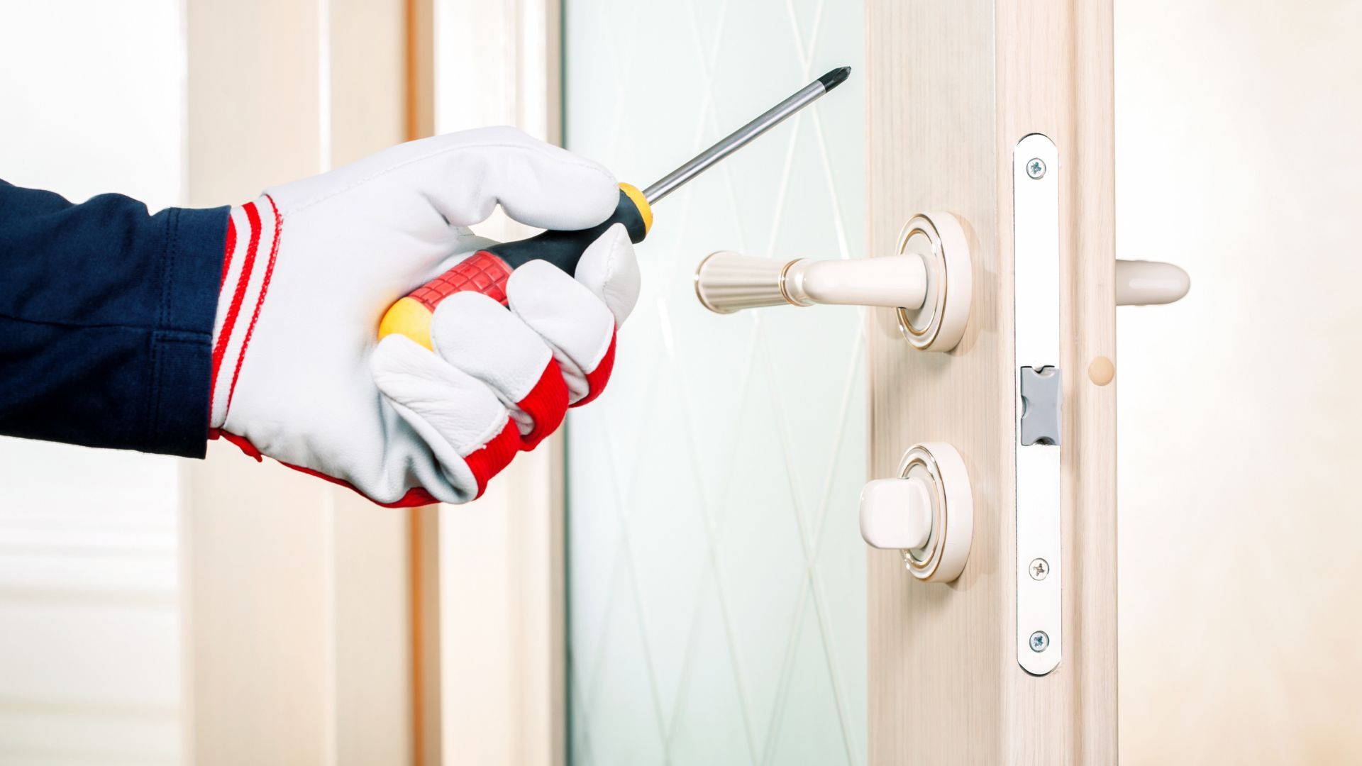 A person is fixing a door with a screwdriver.