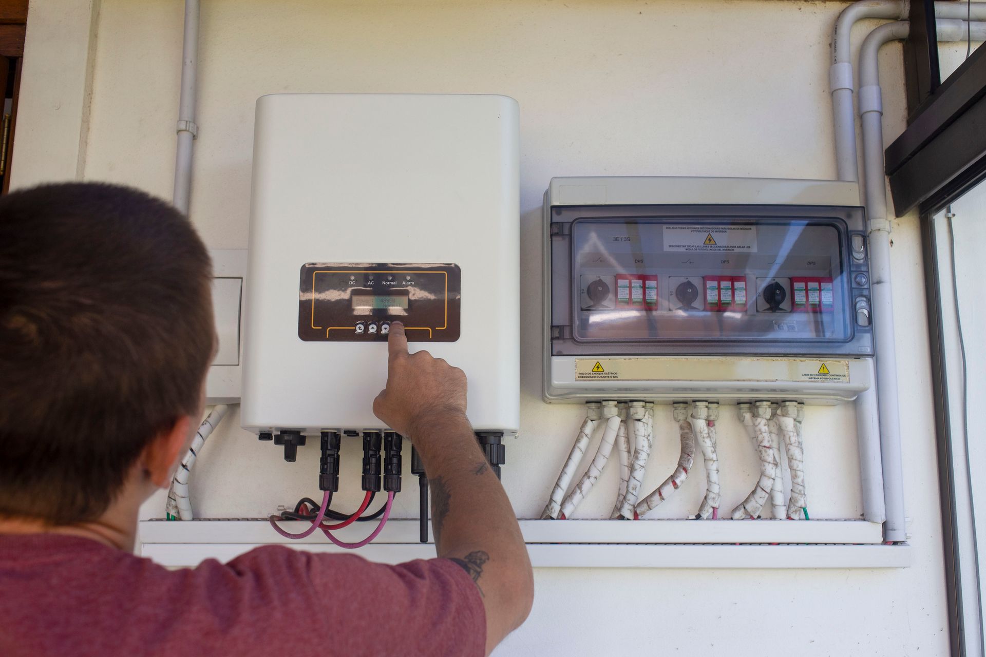 Man setting up solar energy system control panel.