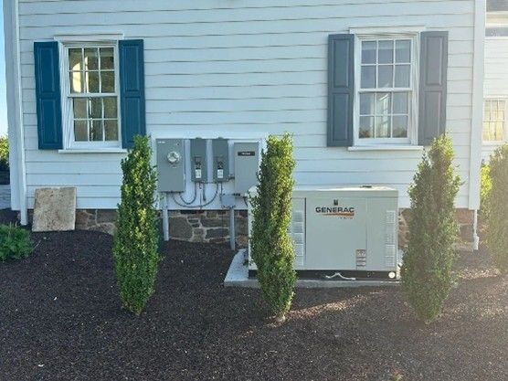 A Generac generator unit is placed on a concrete pad outside a house.