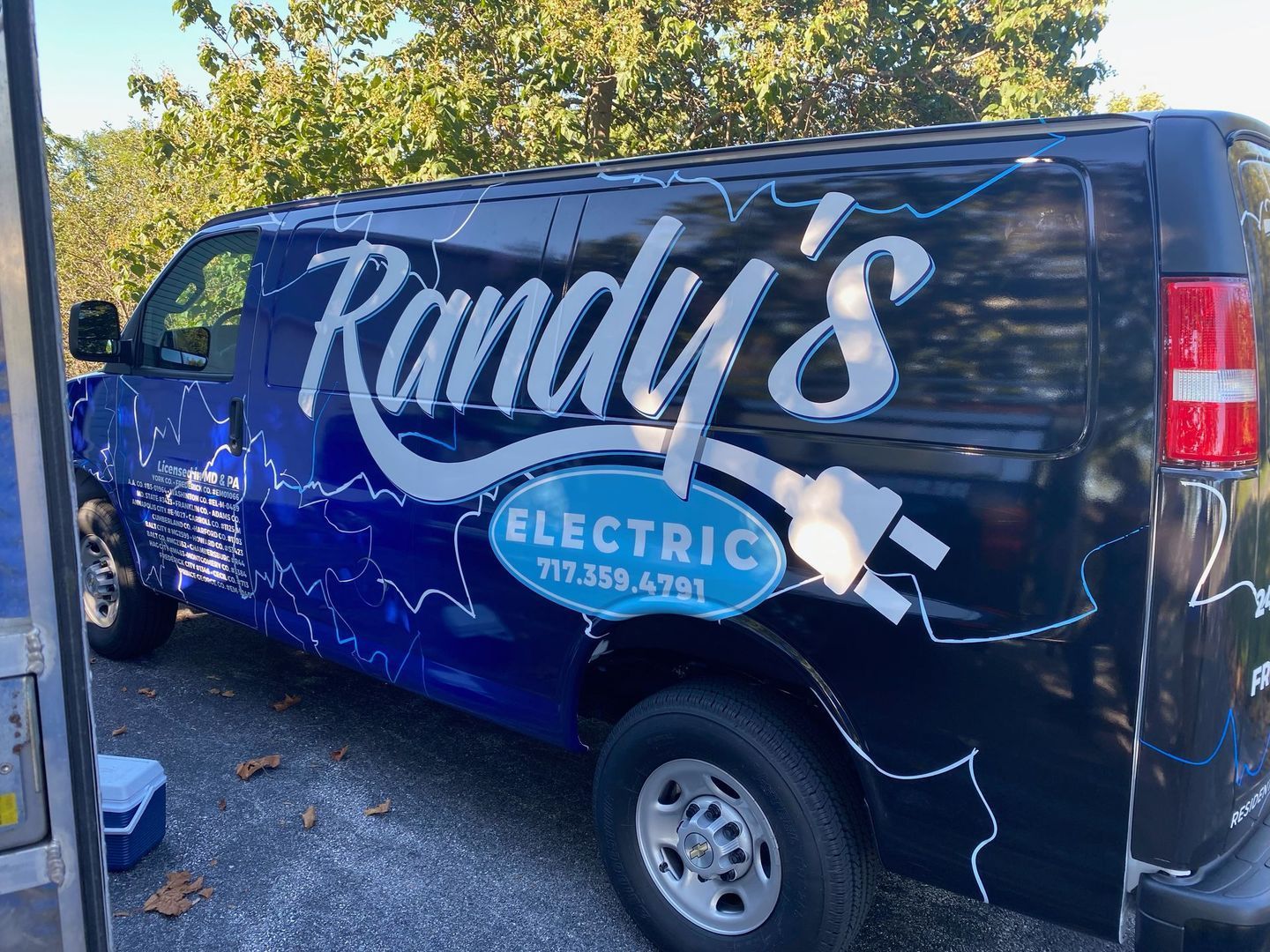 A blue van with the word randy 's electric on it.