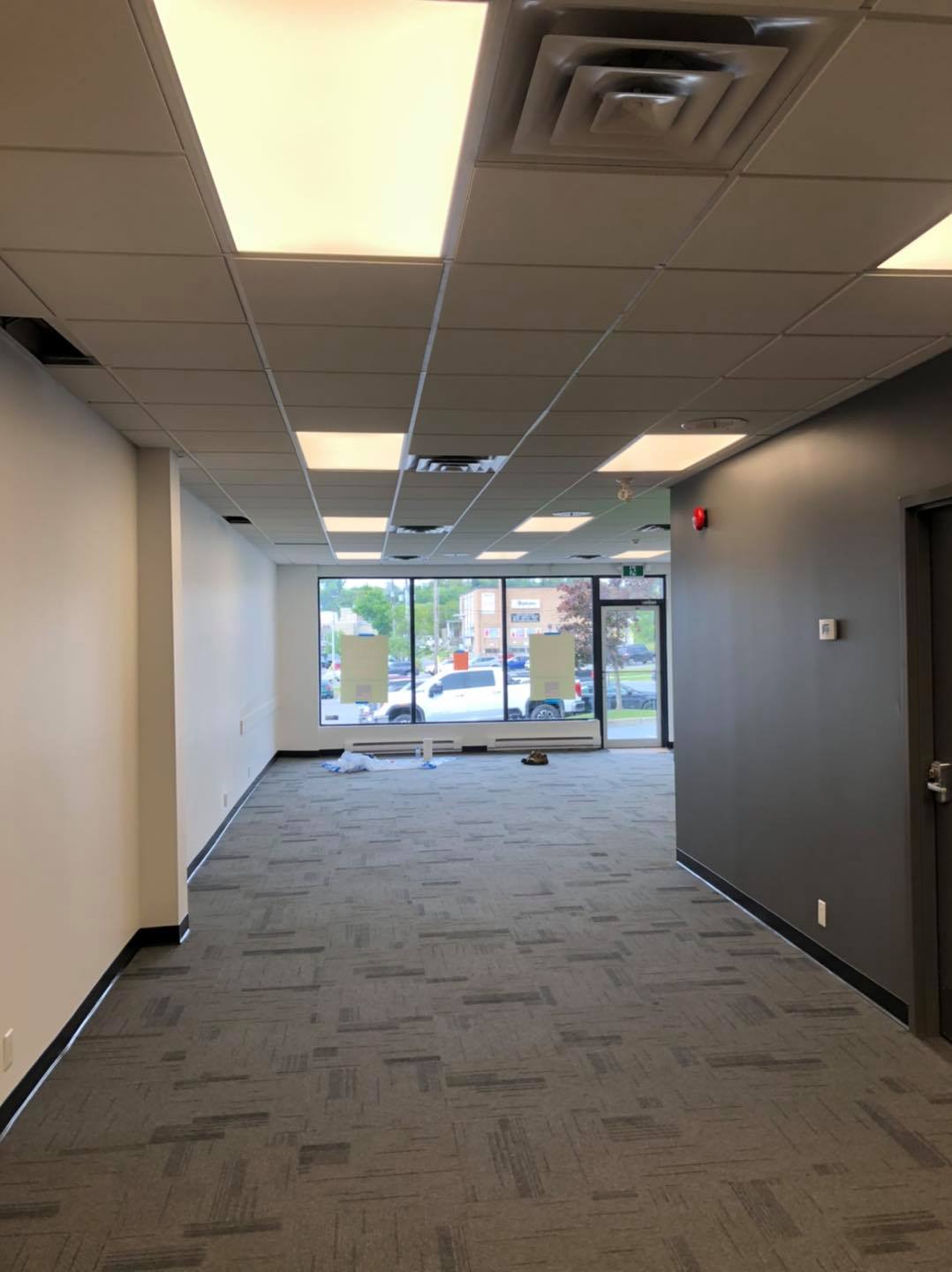 An empty room with a carpeted floor and a window