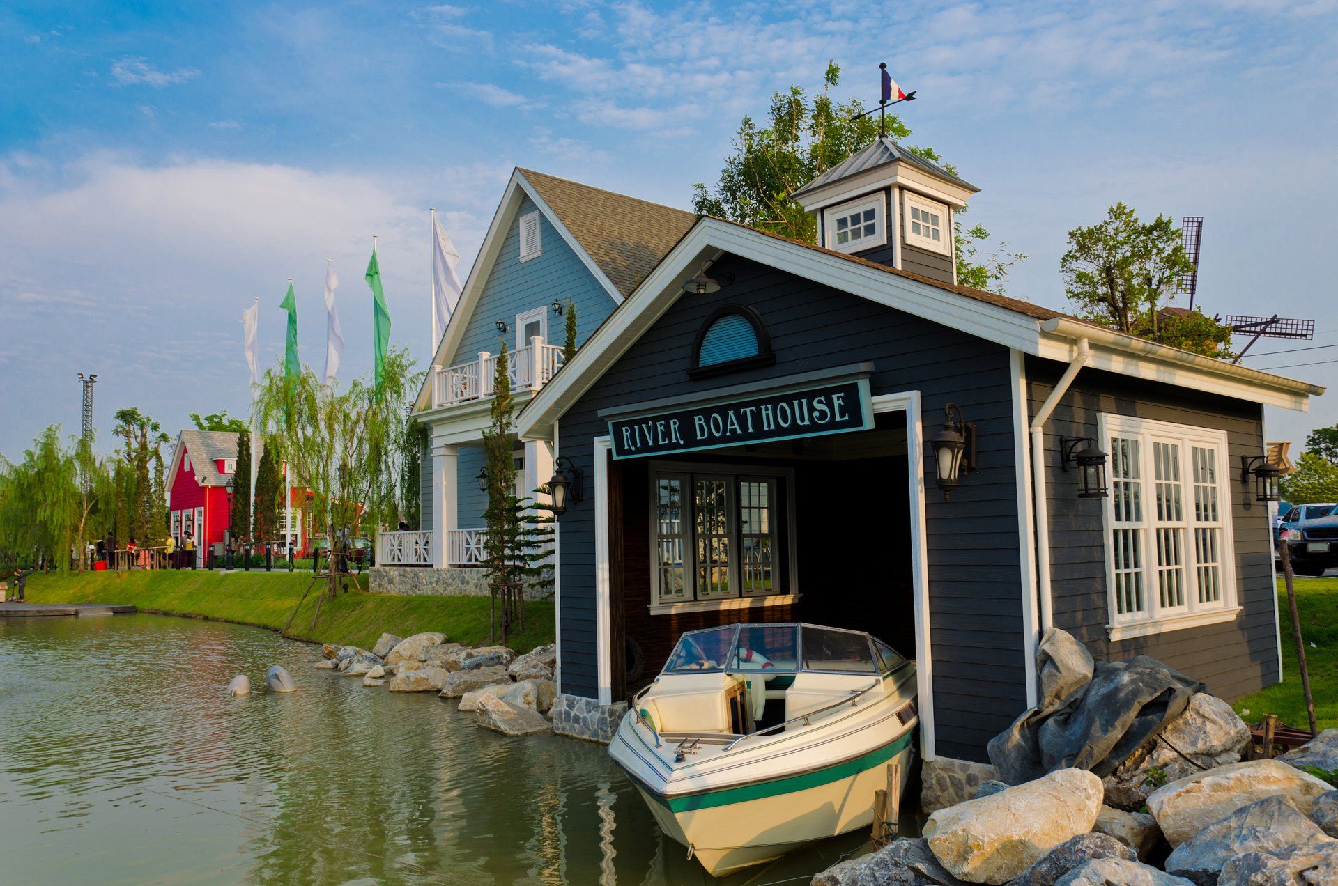 A boat is parked in front of a small house next to a body of water.