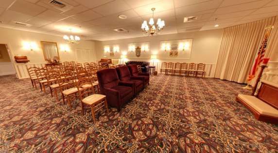 A large room with a couch and chairs in it.