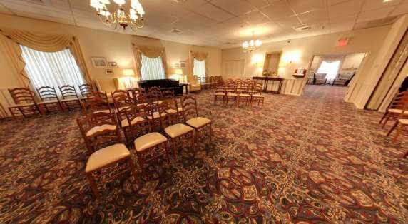 A room with a lot of chairs in it and a chandelier.