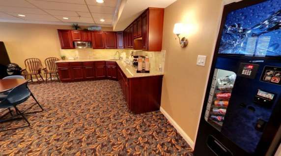 A kitchen with a vending machine and a table and chairs