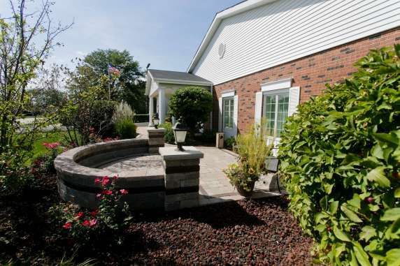 A brick house with a fountain in front of it