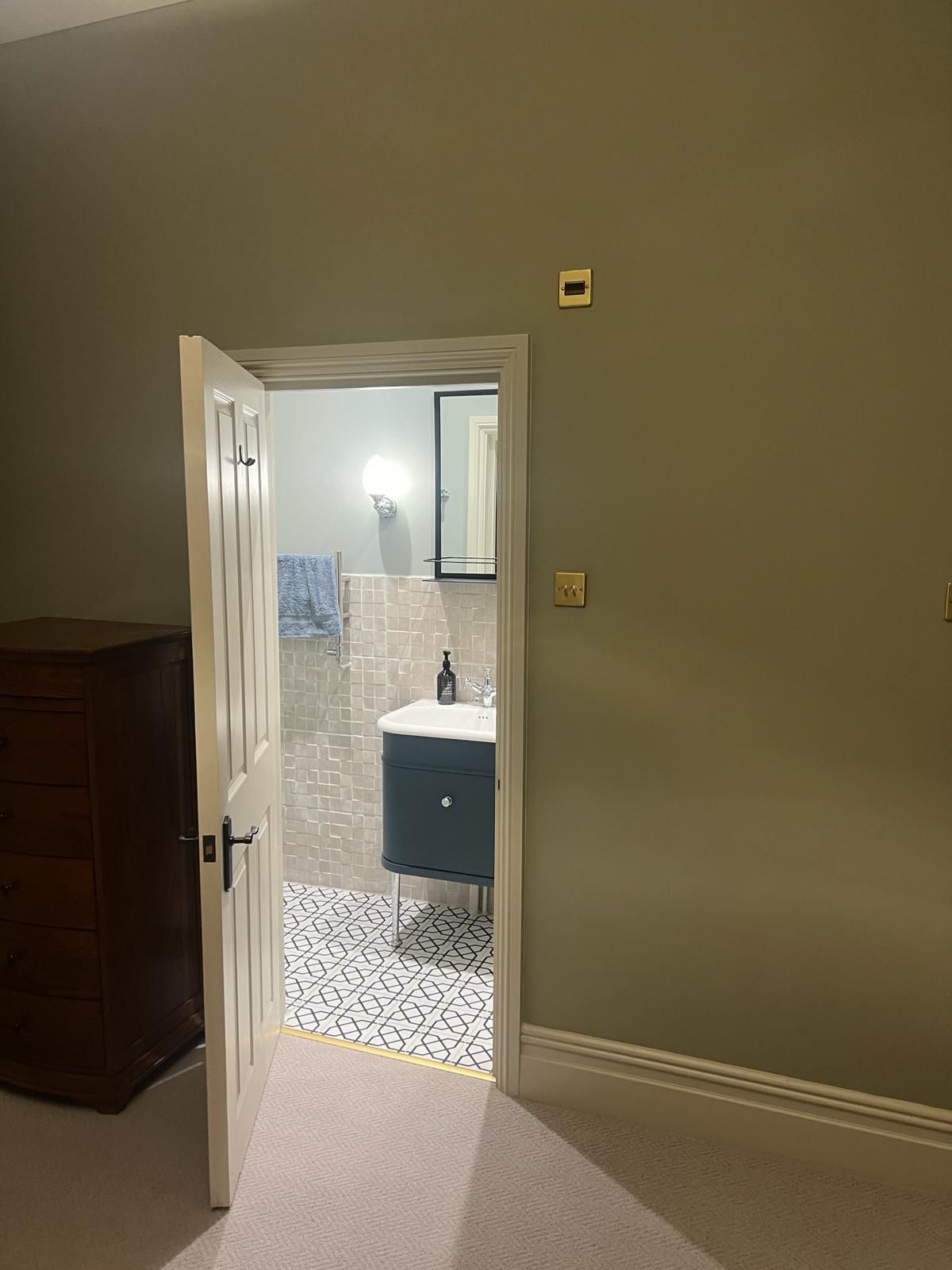 The door is open to a bathroom with a sink and mirror.