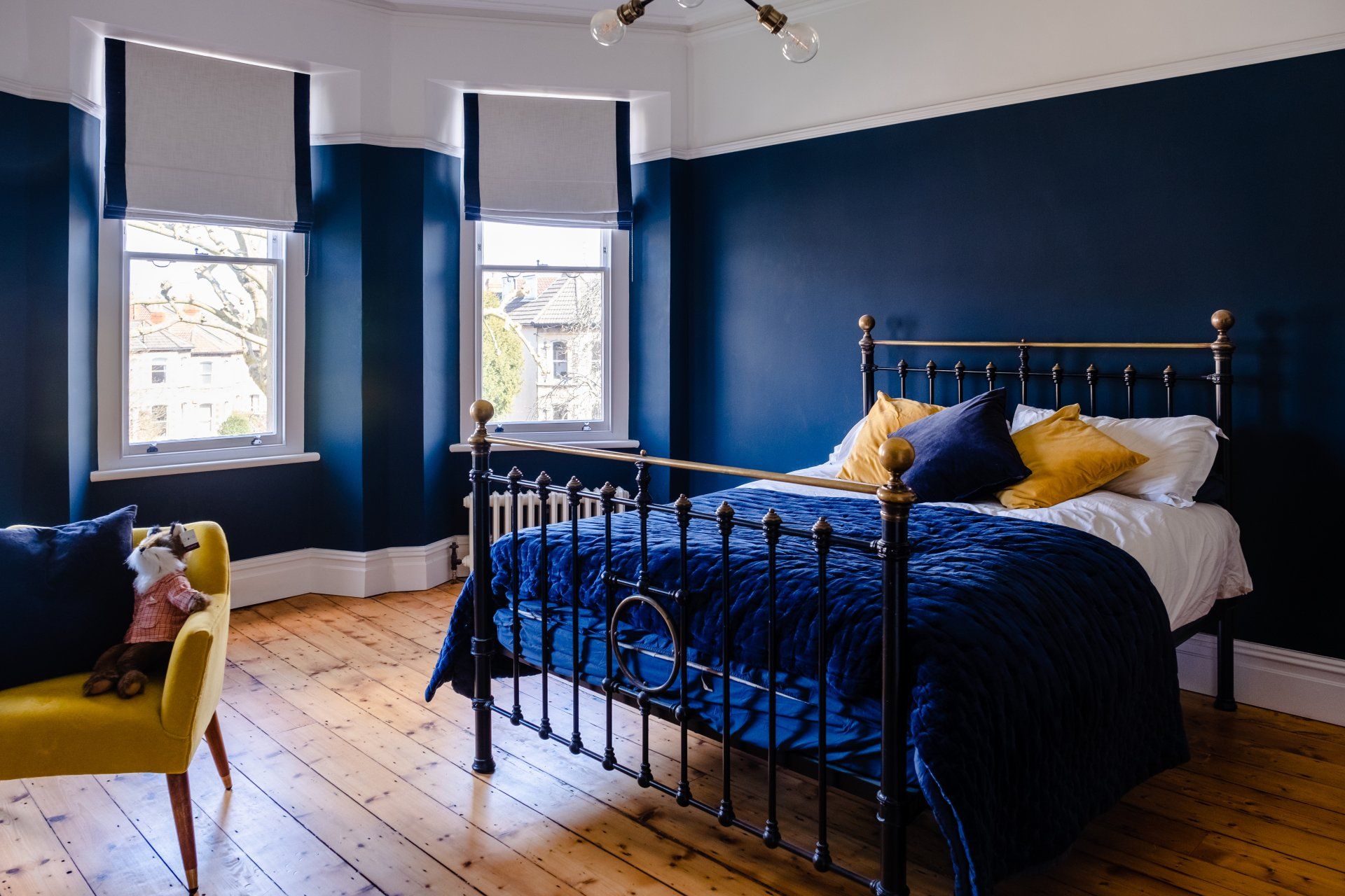 A bedroom with a bed , chair , and blue walls.