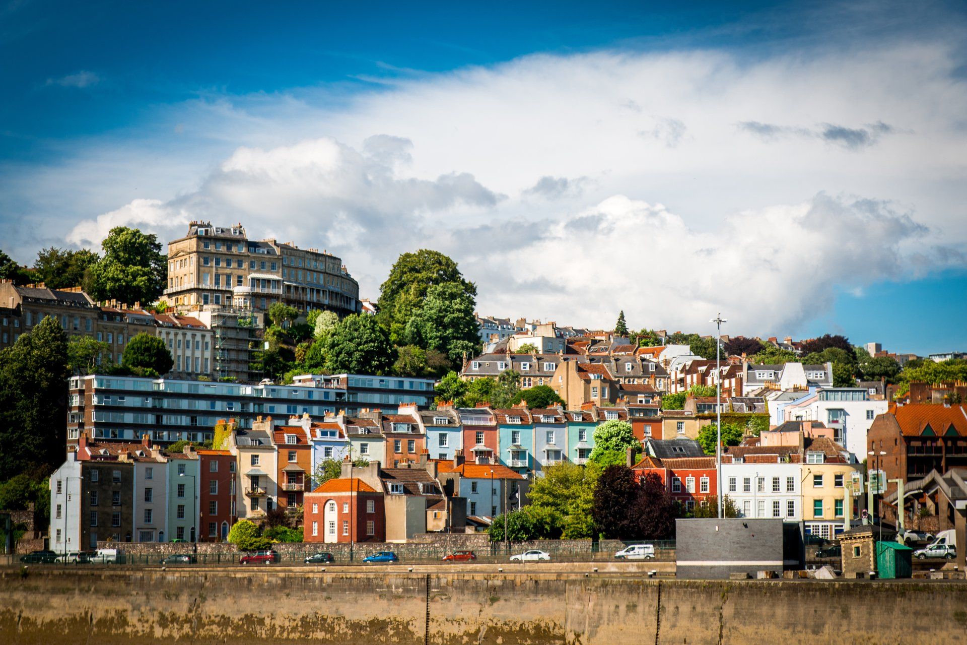 A city with a lot of buildings and a river in the foreground.