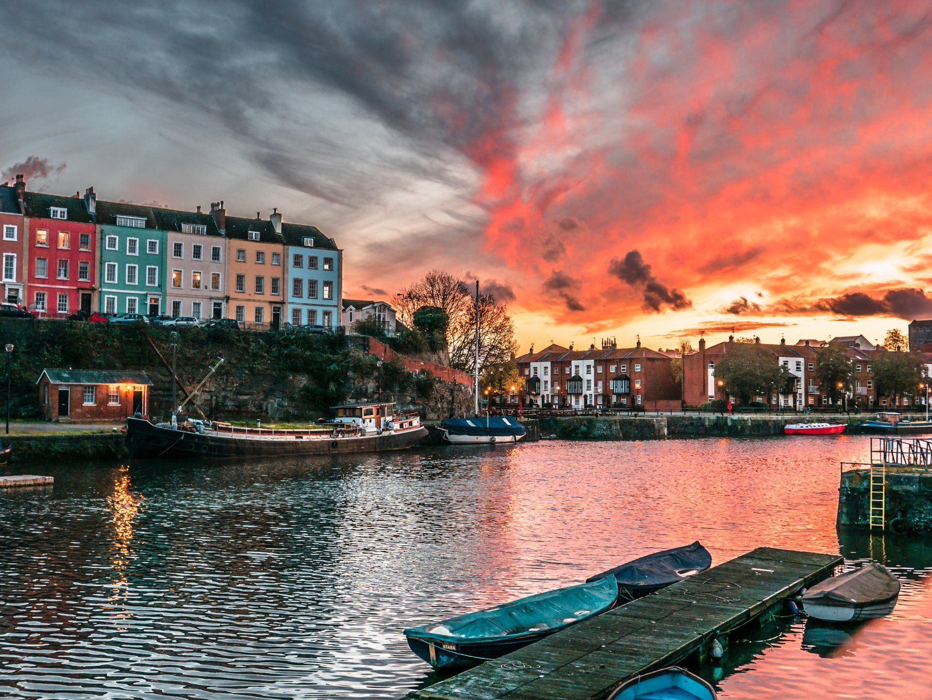 A sunset over a body of water with boats docked on the dock