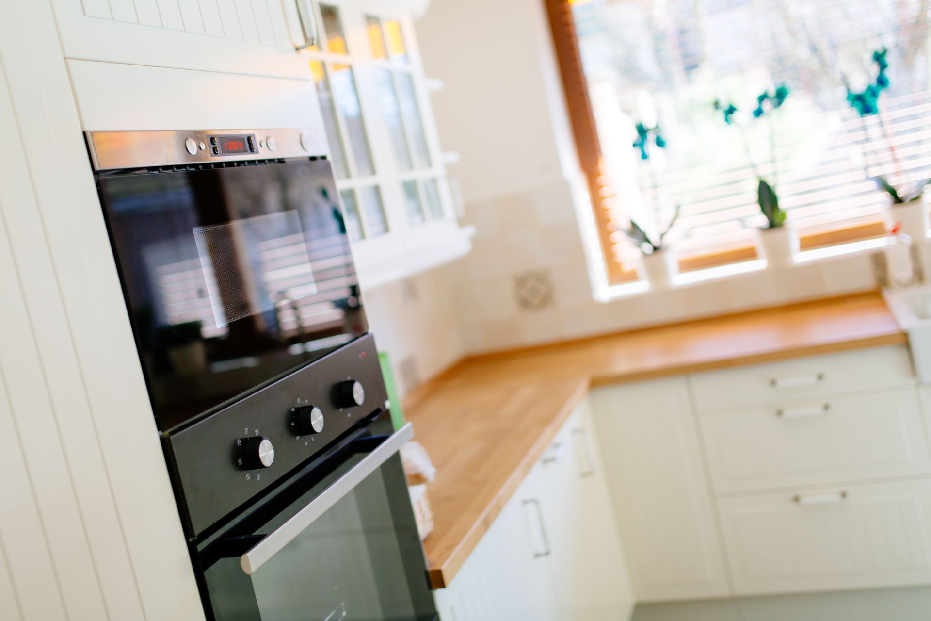 A kitchen with white cabinets and a black oven.