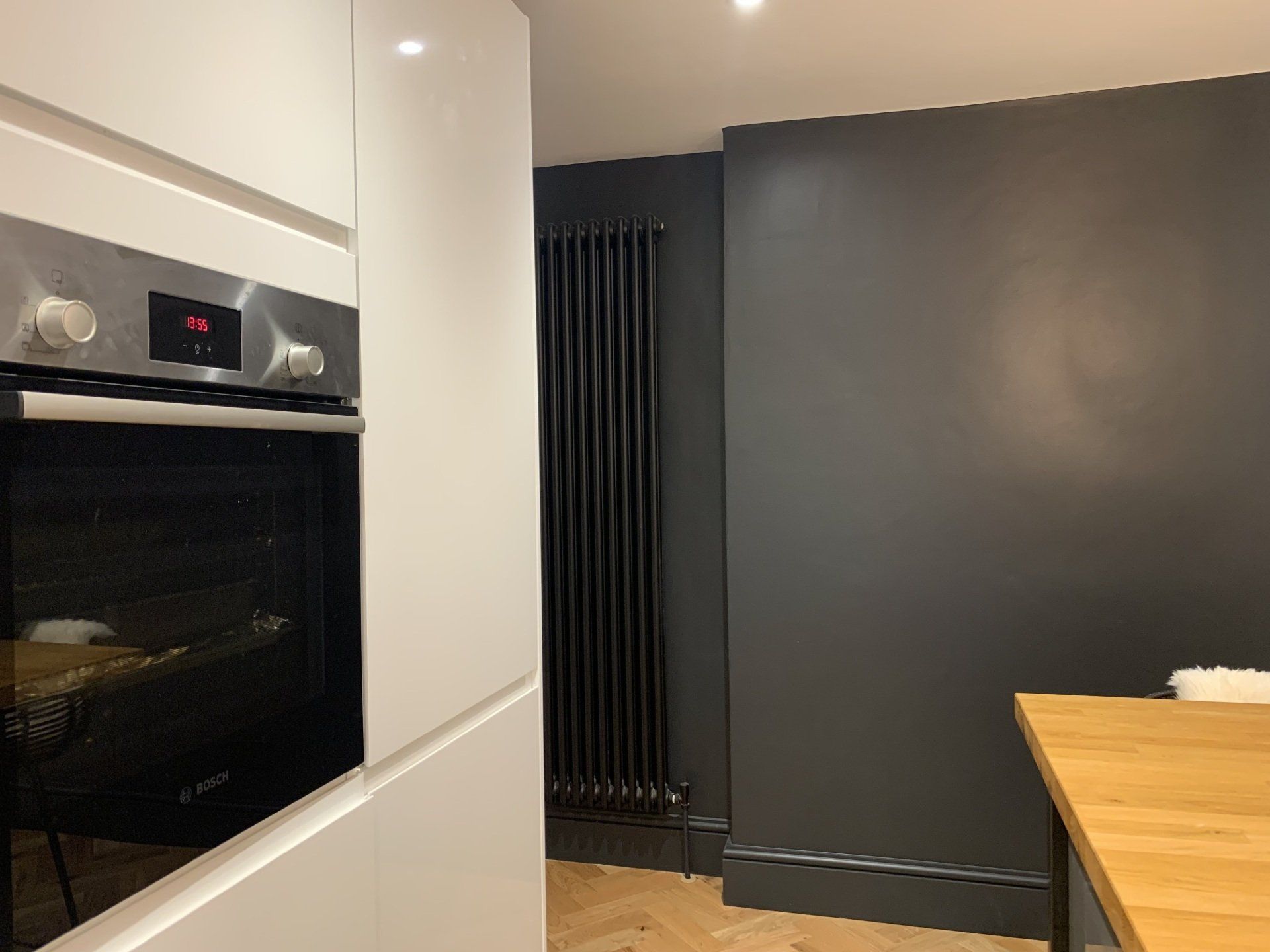 A kitchen with a stainless steel oven and a wooden table.