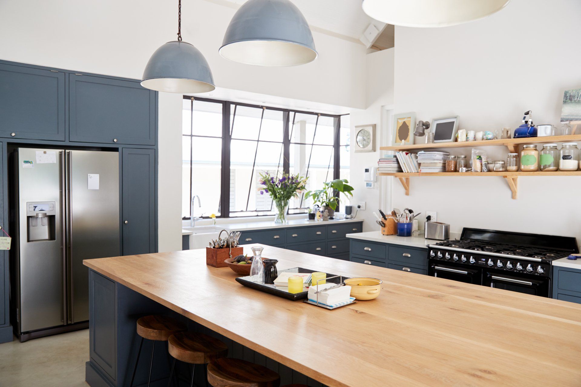 A kitchen with a large wooden table and stools.