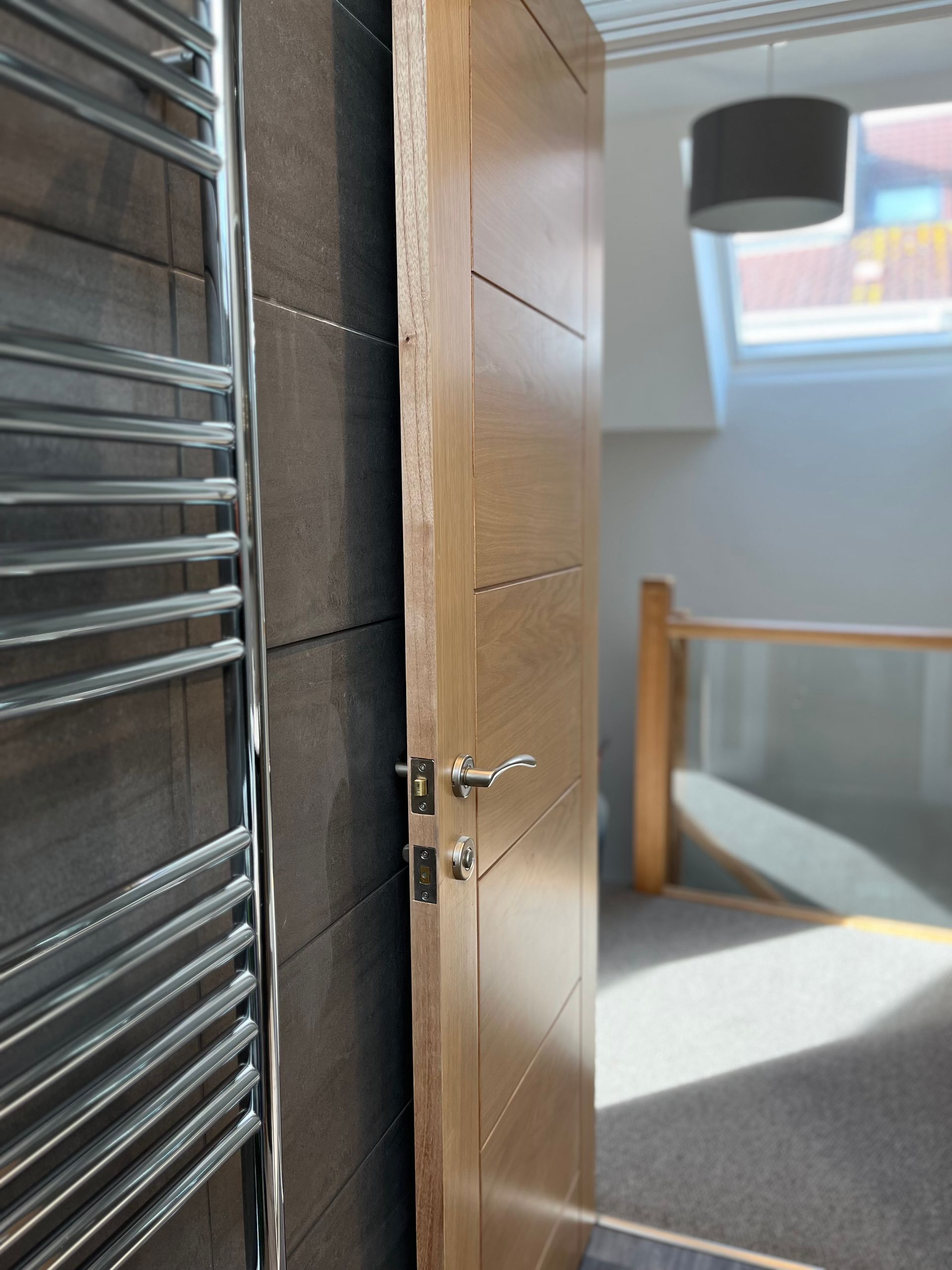 A wooden door with a towel rack next to it