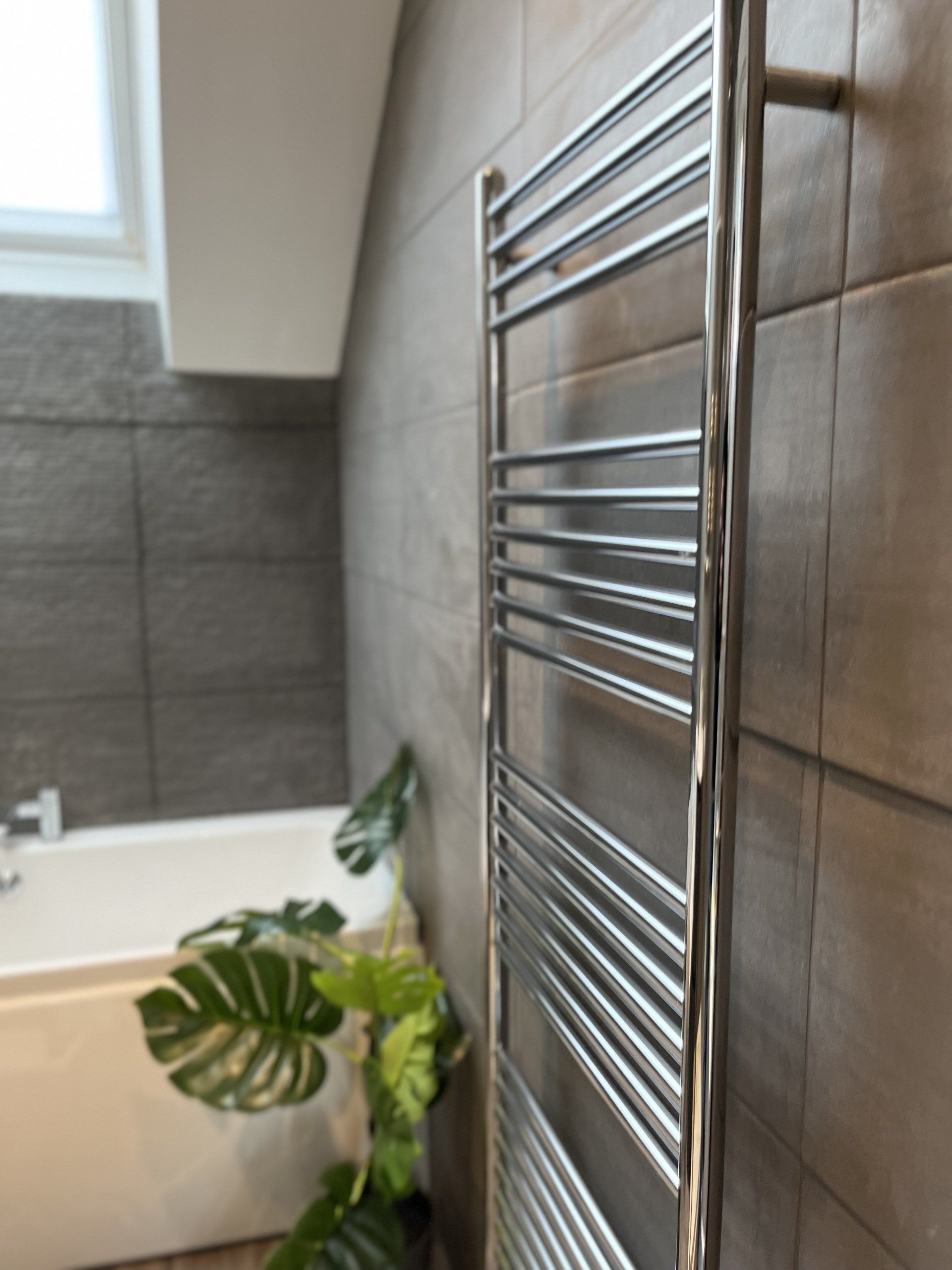 There is a towel rack in the bathroom next to a bathtub.