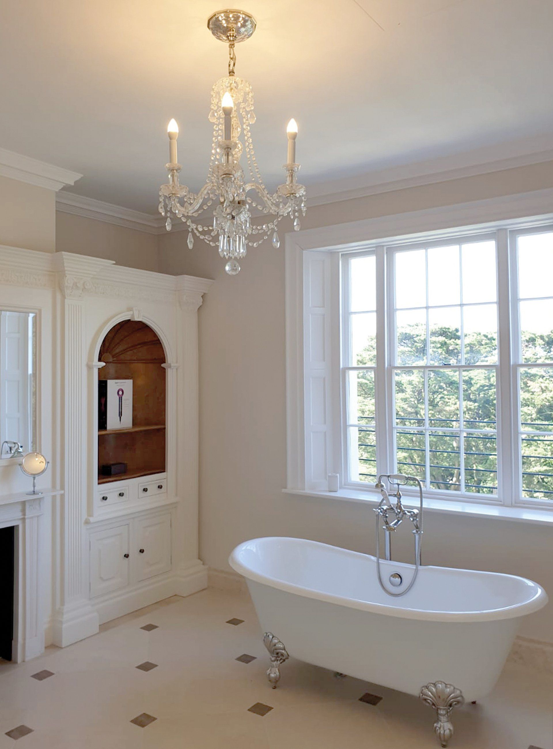 A bathroom with a bathtub and a chandelier hanging from the ceiling.