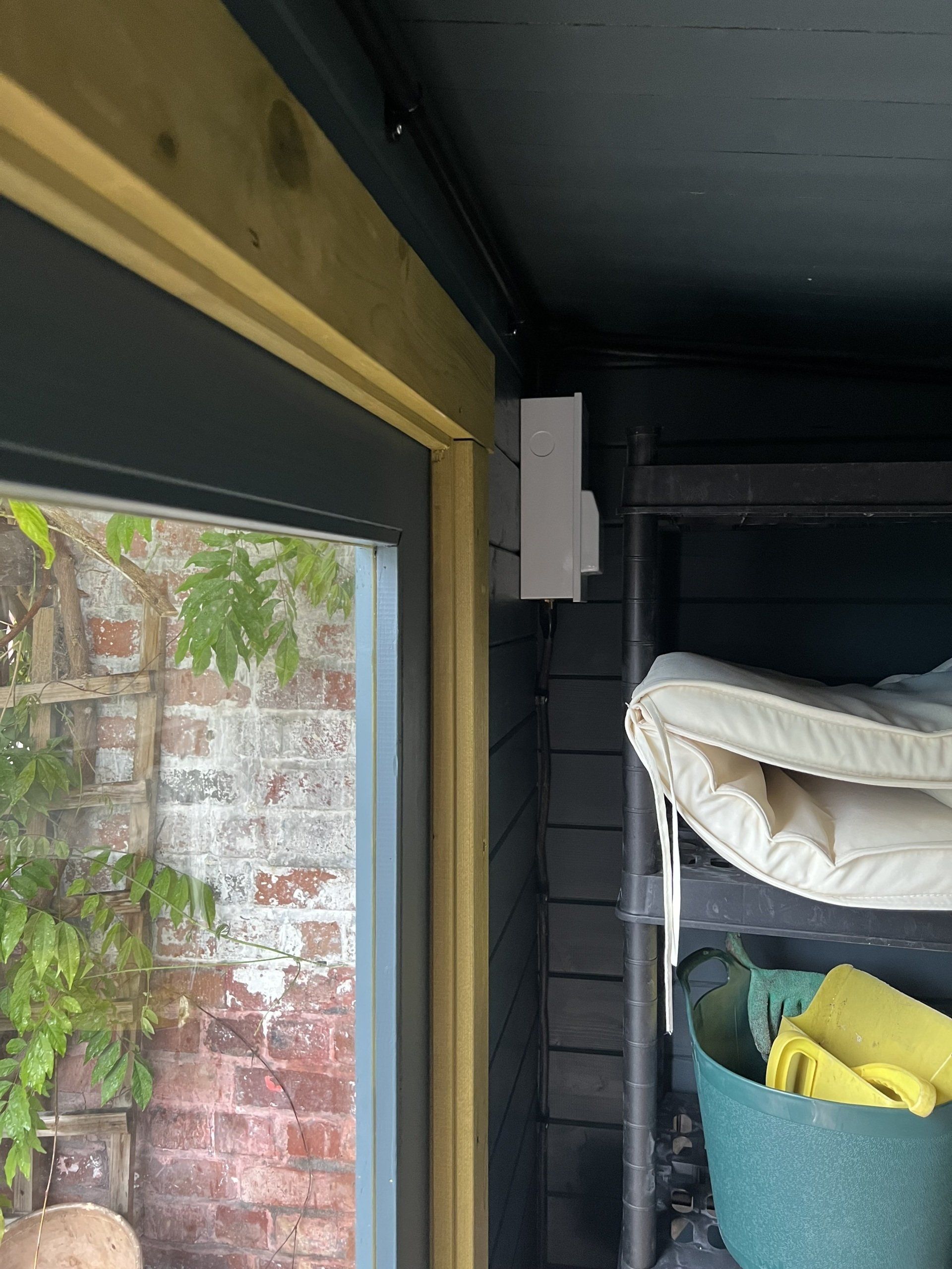 A room with a mattress on a shelf next to a window.
