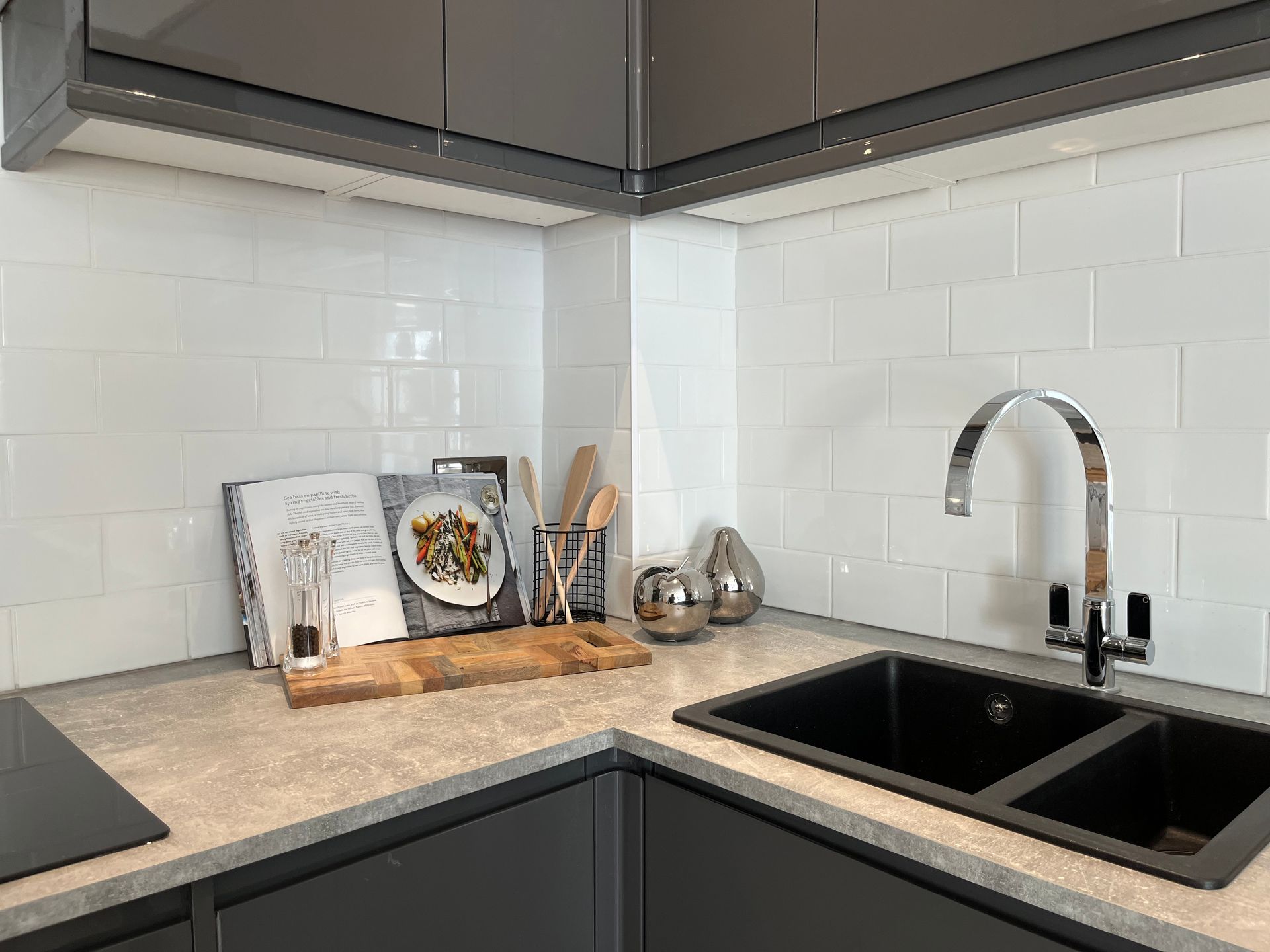 A kitchen with a sink and a cutting board on the counter.