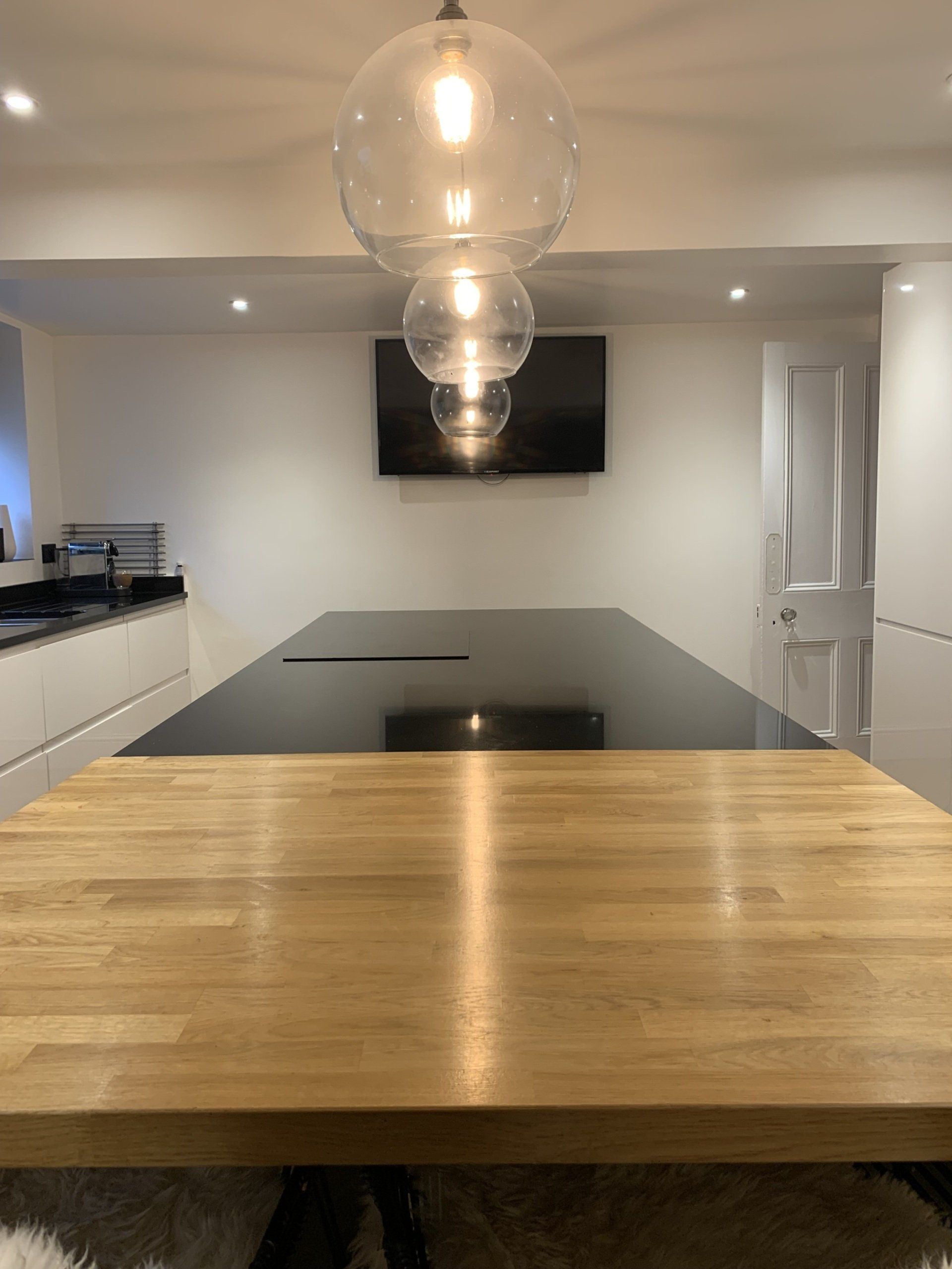 A kitchen with a wooden table and a black counter top.